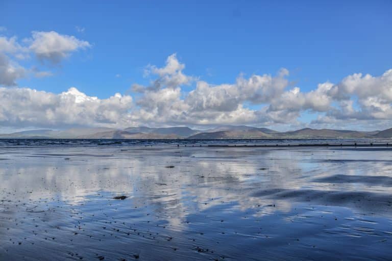 Playa Rossbeigh vacía pronto por la mañana con las nubes reflejándose en la arena, uno de los lugares que ver en el anillo de Kerry