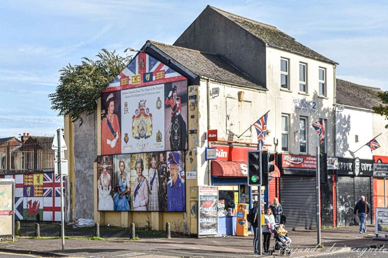 Mural en Schankill Road sobre la reina de Inglaterra y banderas inglesas junto a él