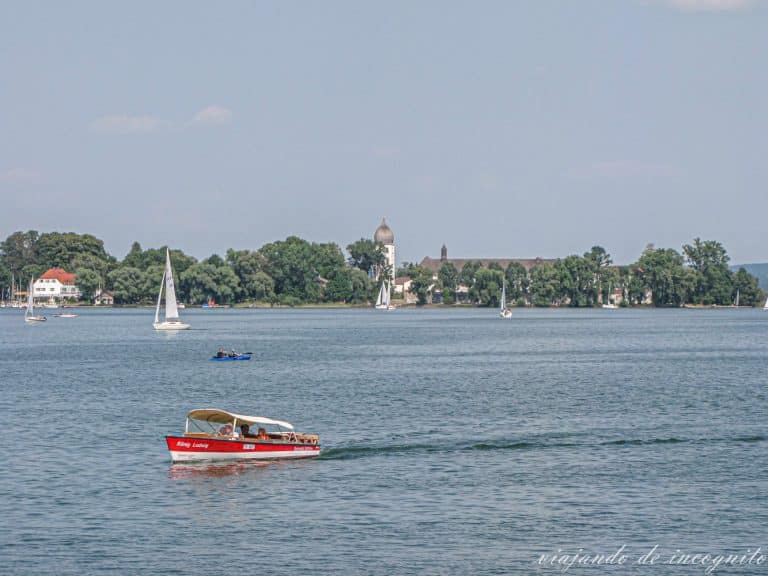 barca pequeña de color rojo navegando frente a la isla de las mujeres en el Chiemsee