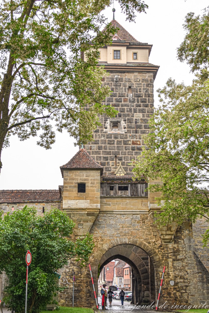 Puerta del patíbulo medio tapada con hojas en Rothenburg ob der Tauber con un soldado en el arco de la entrada