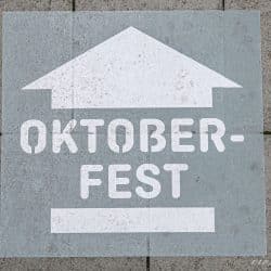 Señal de la Oktoberfest pintada en el suelo con una flecha indicando la dirección de la wiesn