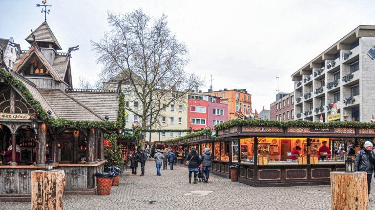 Puestos del Mercado de Alter Markt de Colonia durante el día y con pocos visitantes