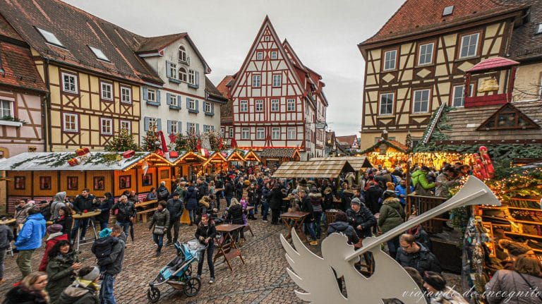 Gente tomando algo en los puestos del mercado de navidad de Bad Wimpfen durante el día