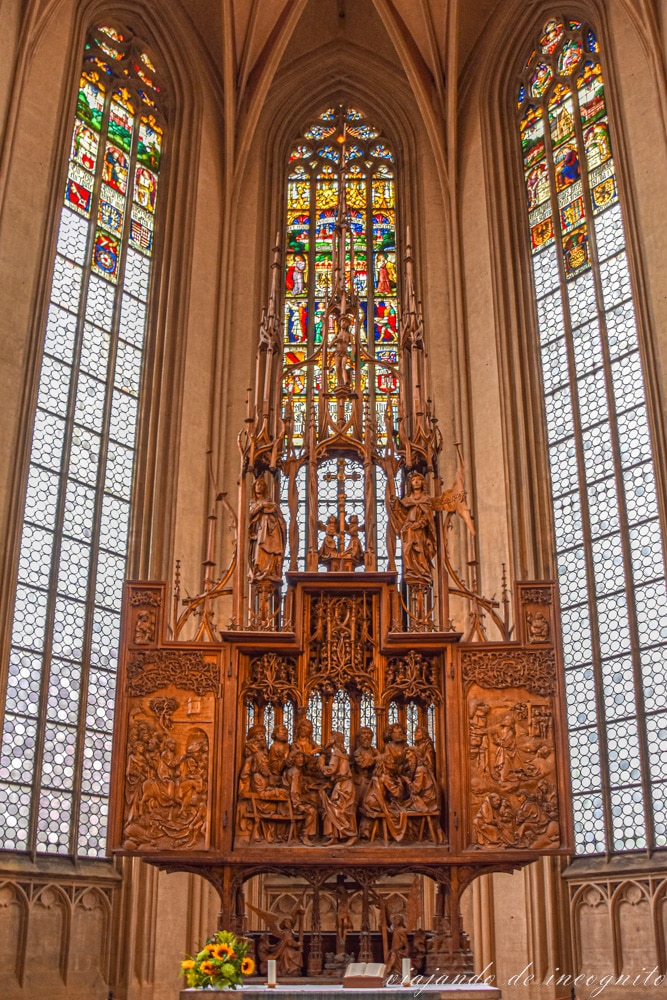 Retablo de madera de la Santa Sangre frente tres altas ventanas