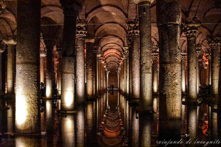 Interior oscuro de la Basílica cisterna con numerosas columnas reflejándose en el agua