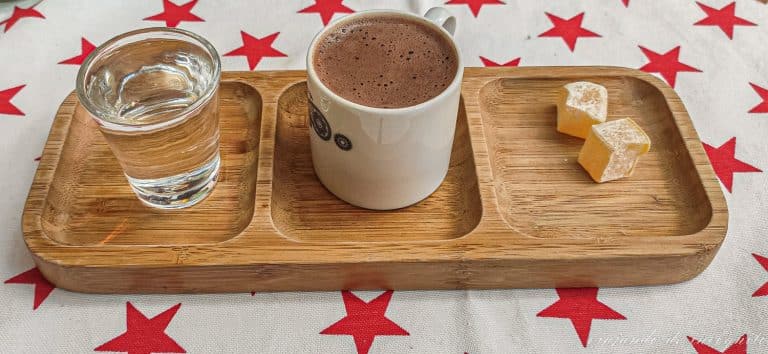 Café turco en una bandeja con tres compartimentos, uno para la taza, otro para el vaso de agua y otro para dos lokum
