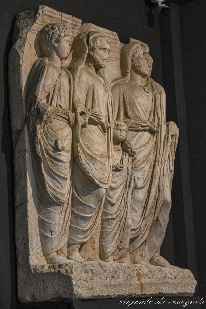 Esculturas de tres hombres y un niño decorando un fragmento del friso del templo de Adriano en el Museo arqueológico de Éfeso