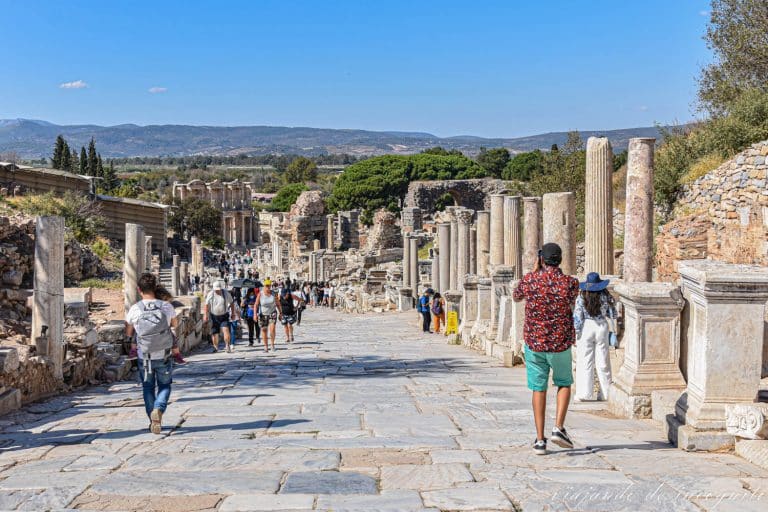 Turistas recorriendo la avenida de los curetes de la Antigua ciudad de Éfeso con la biblioteca de Celso al fondo