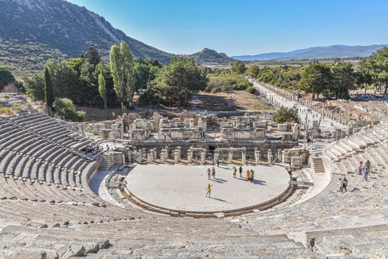 Vista desde arriba del gran teatro de la Antigua ciudad de Éfeso con unas diez personas visitándolo