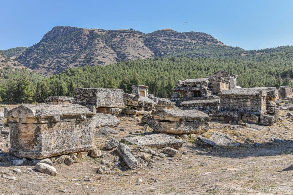 Tumbas de la Necrópolis de Hierápolis con árboles y colinas al fondo. Pamukkale