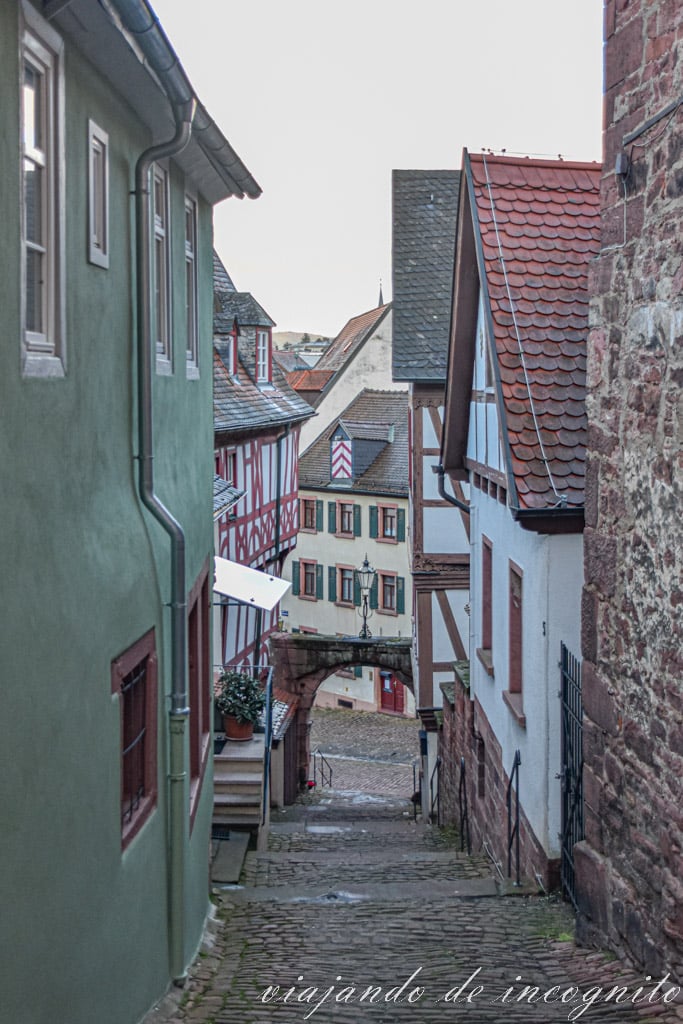Calle estrecha y empinada que termina en un pequeño arco de piedra y flanqueada por casas de piedra y de entramado de madera