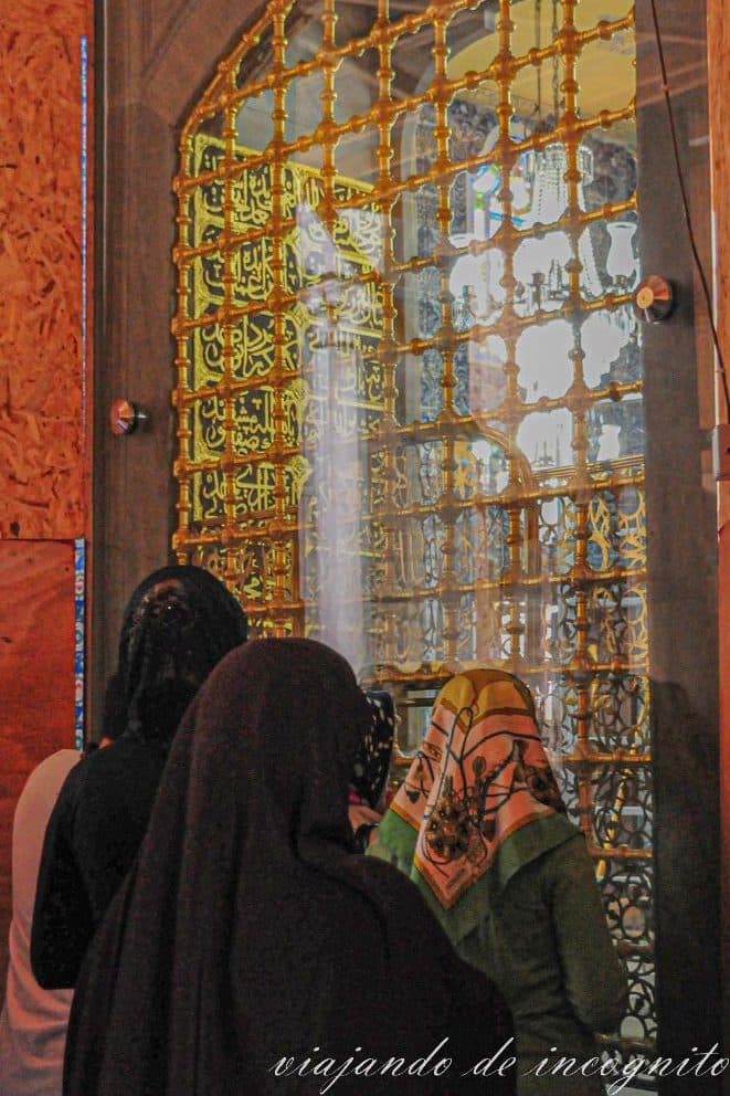 Mujeres con la cabeza cubierta por un pañuelo rezando frente a una ventana en la mezquita de Eyüp