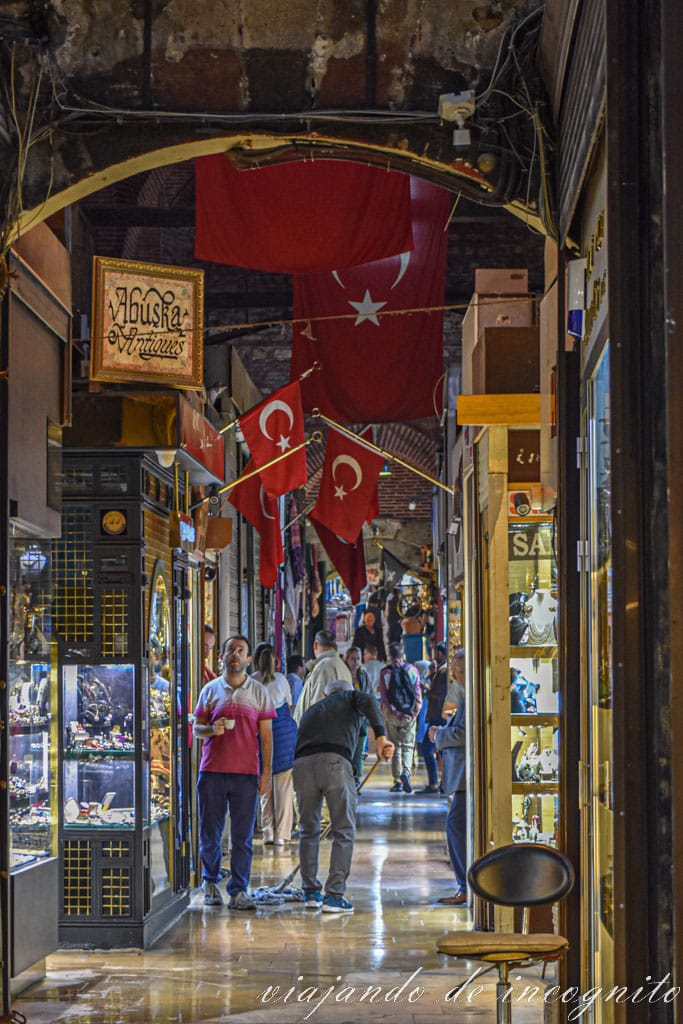 Hombre fregando en una Calle del Gran Bazar decorada con banderas turcas