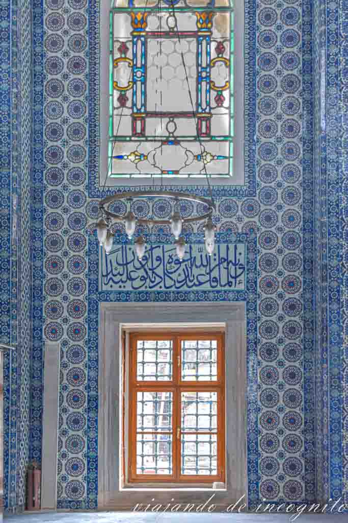 Pared interior de la Mezquita Rüstem Pasha tcon dos ventanas y cubierta con azulejos bancos y azúles de diferentes motivos geométricos
