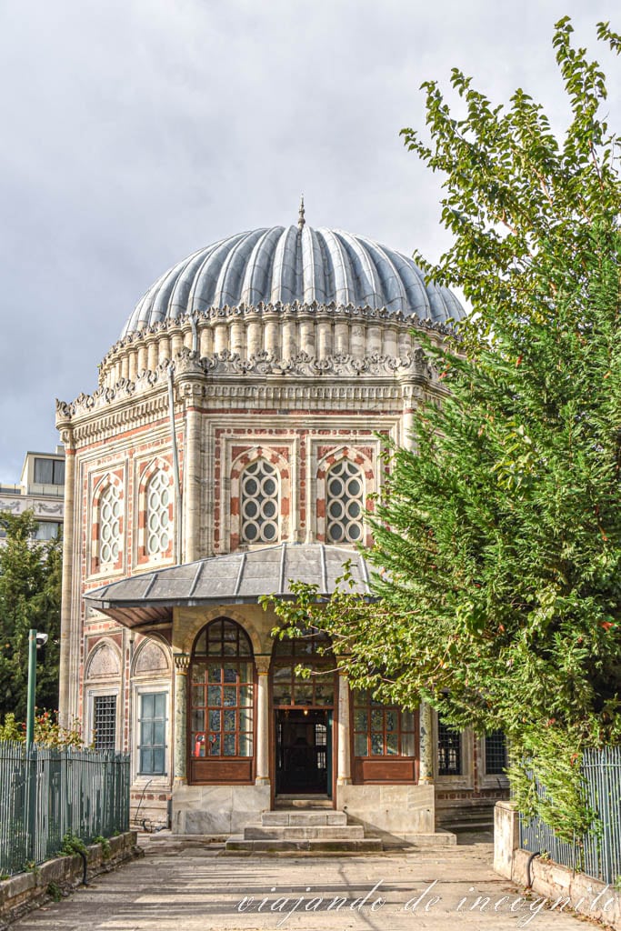Mausoleo de Şehzade medio tapado por las hojas de un árbol verde