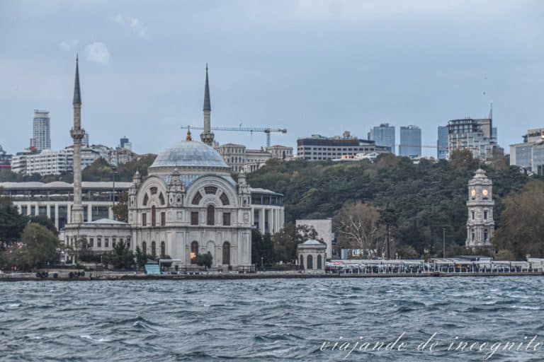 Torre del Reloj y mezquita de Dolmabahce desde el Bósforo mientras comienza a anochecer