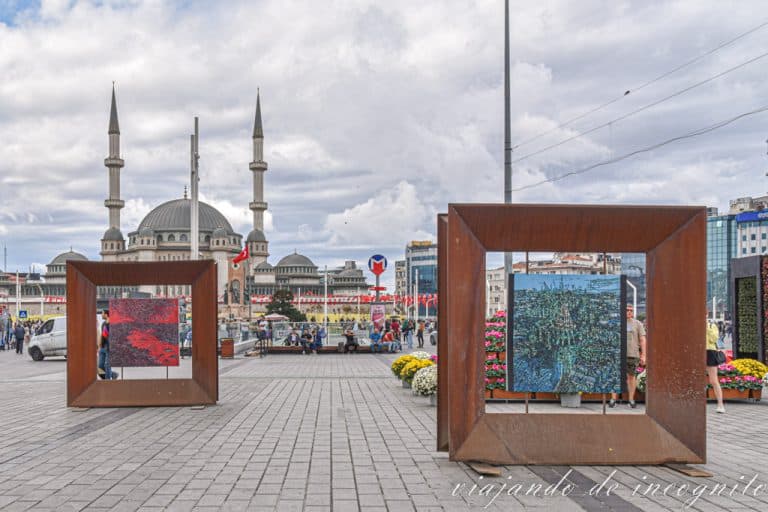 Cuadros decorando la plaza Taksim, junto a una de las salidas del metro y con la mezquita al fondo