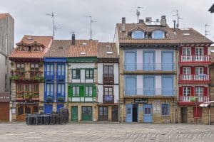 Casas de bajas y estrechas con balcones de colores en la plaza de Armas de Hondarribia.