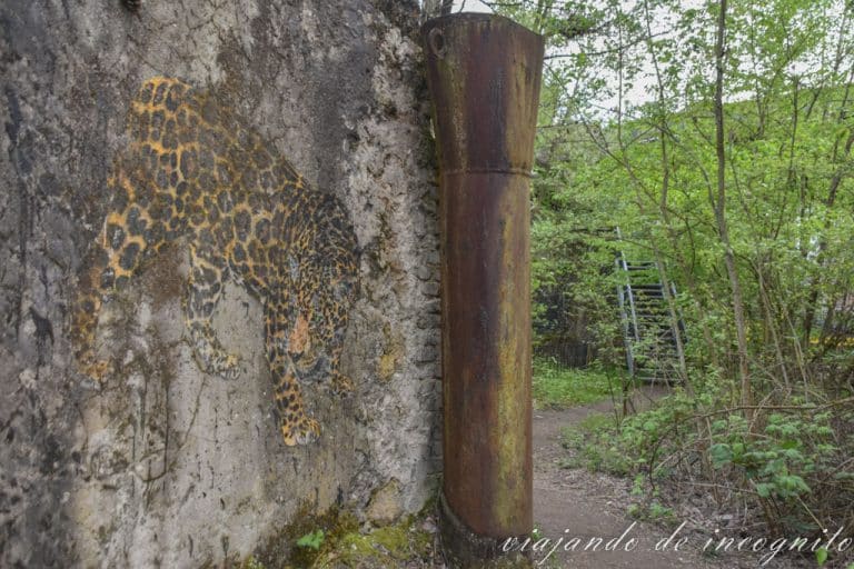 dibujo de un tigre en en los restos de una pared rodeada de árboles en Völklingen Ironworks