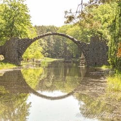 Puente Rakotz y reflejo circular perfecto en el agua con luz cálida