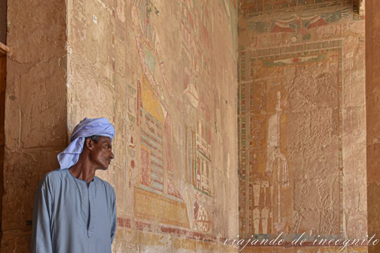 Egipcio apoyado en una pared decorada del templo de Hatshepsut