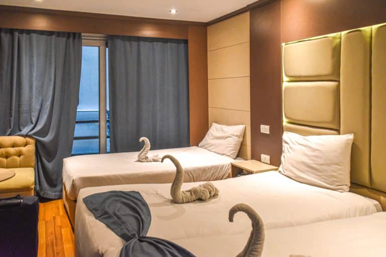 Habitación triple con cisnes hechos con toallas encima de las camas en el barco Zeina