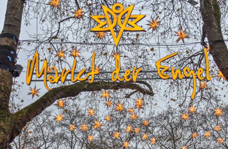Entrada al mercado de navidad del ángel en Neumarkt Colonia con estrellas decorando las copas de los árboles
