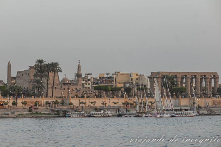 Vistas desde la otra orilla del templo de Luxor, la mezquita y los barcos amarrados en el río al atardecer