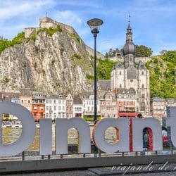 Letras de Dinant junto al rio Mosa. Al fondo se ve la ciudadela, la colegiata y las casas que la rodean. LLegar hasta aquí es una de las cosas que hacer en Dinant