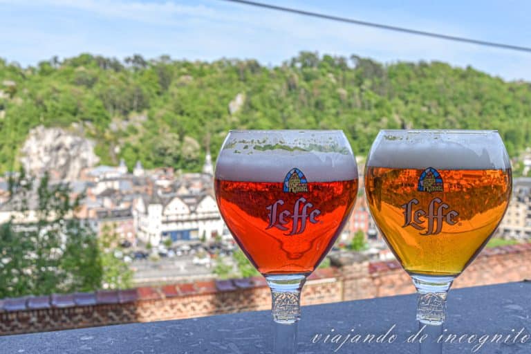 Dos vasos de cerveza Leffe con el paisaje del valle del Mosa al fondo