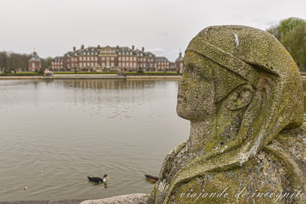 Escultura de piedra de una esfinge frente al lago que rodea el palacio de Nordkirchen en un día gris. Uno de los lugares que ver en Münsterland
