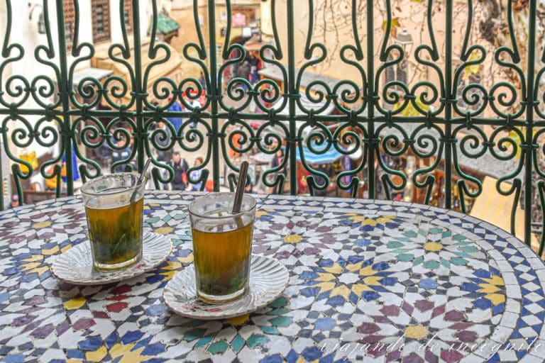 Mesa decorada con azulejos y dos tazas de té con menta en una terraza en la plaza Seffarine