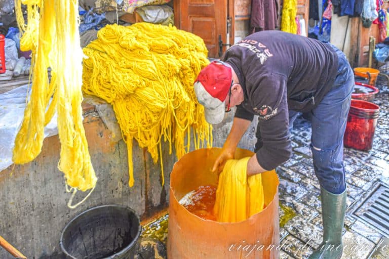 Trabajador tiñe las lanas de color amarillo