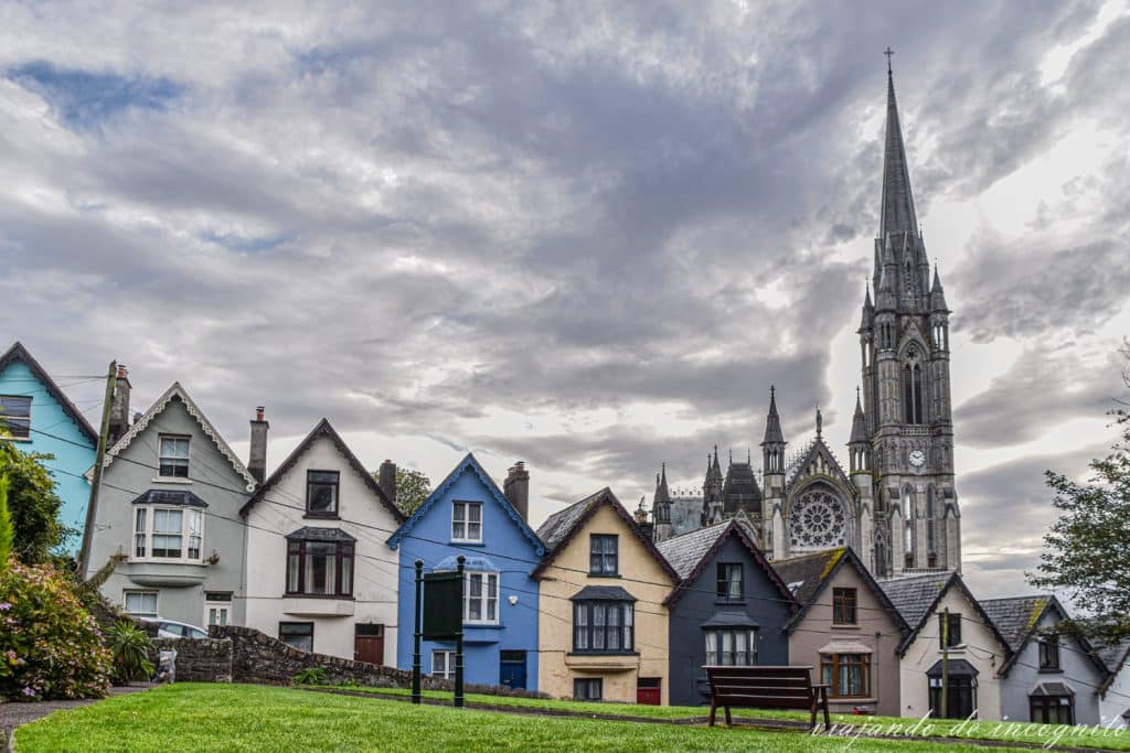 Hilera de casas con fachadas de colores a lo largo de West View. Al fondo se asoma la catedral de San Colman. Sin duda, uno de los lugares que ver en Cobh