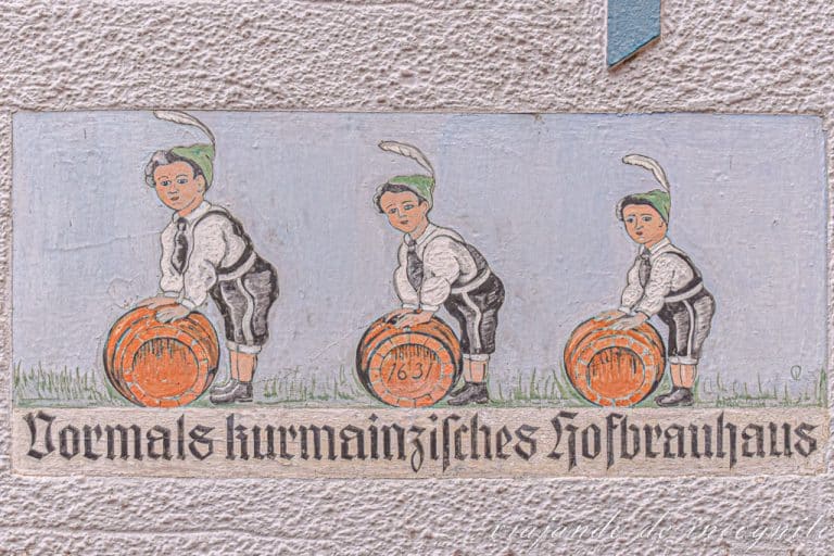 Dibujo pintado en la pared de una cervecería alemana. Se ve a tres niños empujando cada uno un barril de cerveza