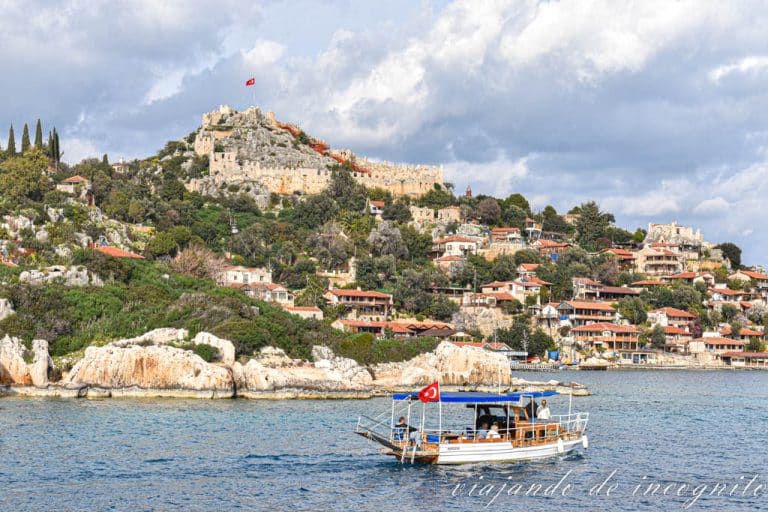 Un barco con bandera turca navega frente a Kaleköy, un pueblo en la Costa Turquesa