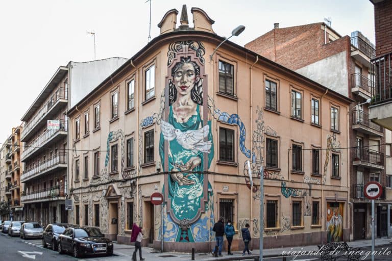 Mural de una chica con una paloma en una casa en el barrio del Oeste.