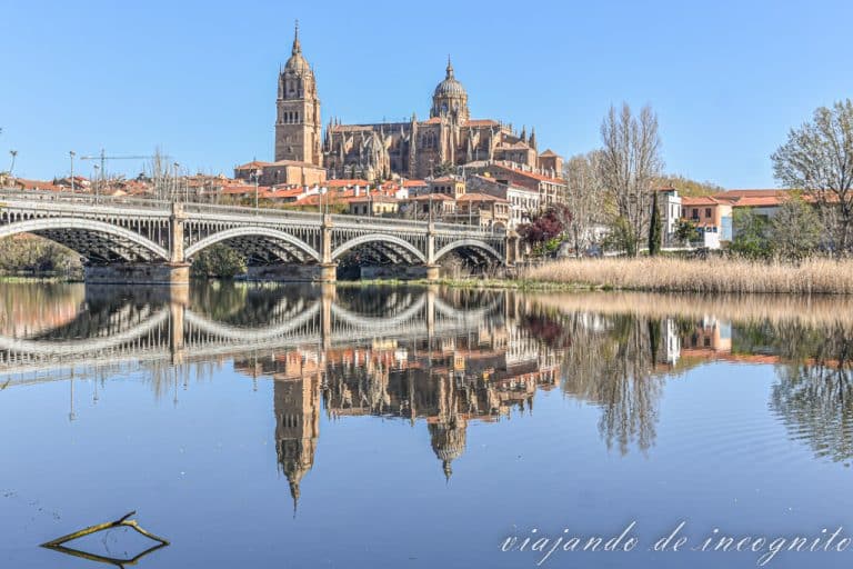 Vistas de la catedral de Salamanca y del puente de Enrique Esteban reflejados en el río Tormes.