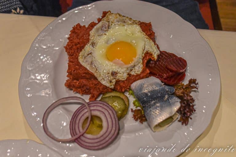 Plato de Labskaus con huevo frito, arenque y remolacha