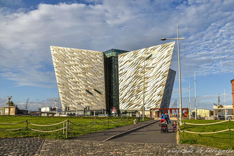 Un padre lleva de la mano a una niña frente al museo del Titanic en Belfast