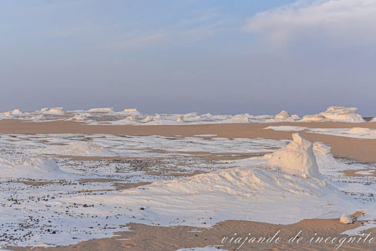 Amanecer en el desierto blanco. Se ven capas de piedra blanca sobre la arena