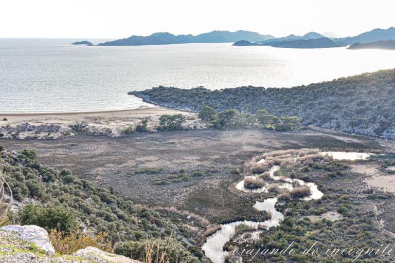 Paisaje en los alrededores de Kas. Se ve el mar es islas al fondo, asícomo un sío que serpentea hasta el agua.