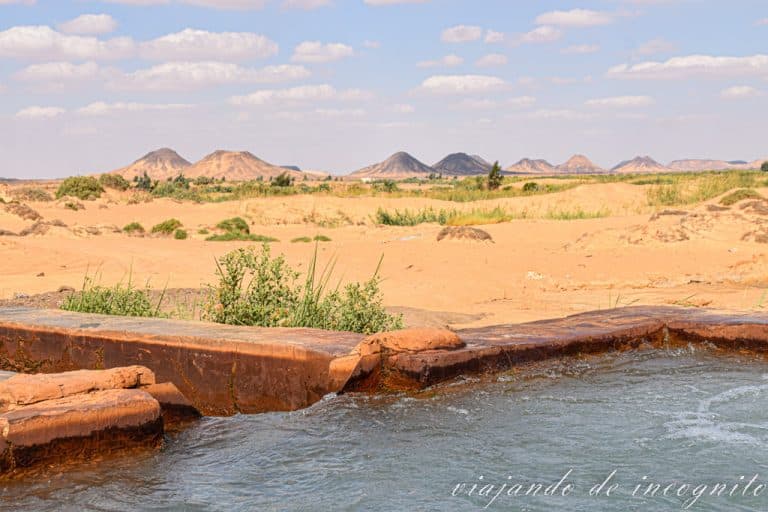 Piscina termal con las colinas del desierto negro al fondo