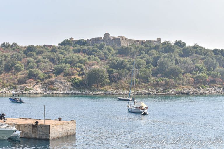 Vista exterior del castillo de Porto Palermo encaramado en lo alto de un trozo de tierra que se adentra al mar.