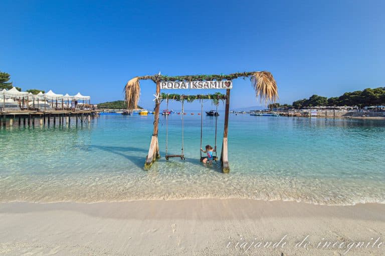 Una niña juega en el columpio de Poda Beach, una de las playas más bonitas que ver en una ruya por Albania