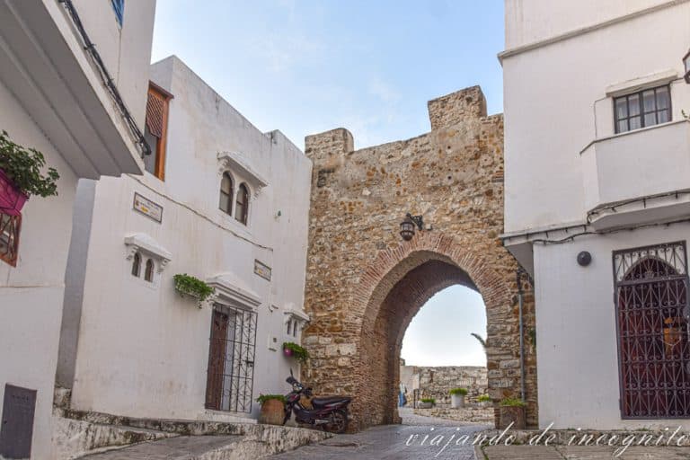 Una de las puertas de la Kasbah rodeada de edificios blancos.