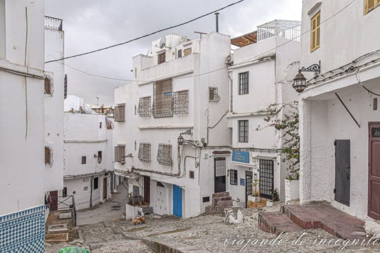 Calle empinada de la Medina de Tánger donde se levantan varias casas de baja altura y color blanco.