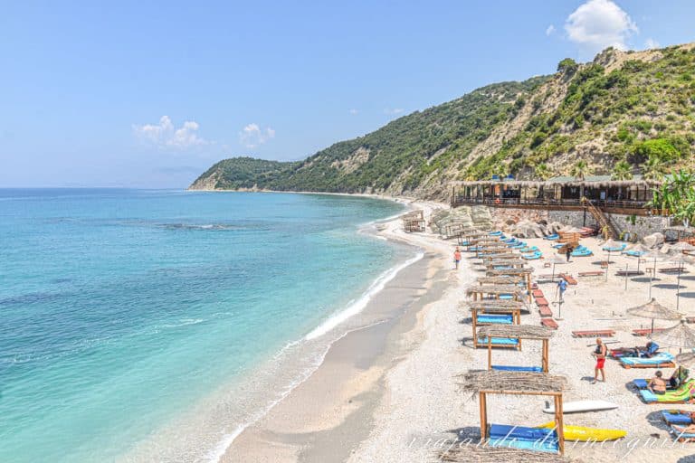 Playa de Lukova con camas balinesas y sombrillas, pero vacía. Esta fue una de las playas que más nos gustó en nuestra ruta por Albania.