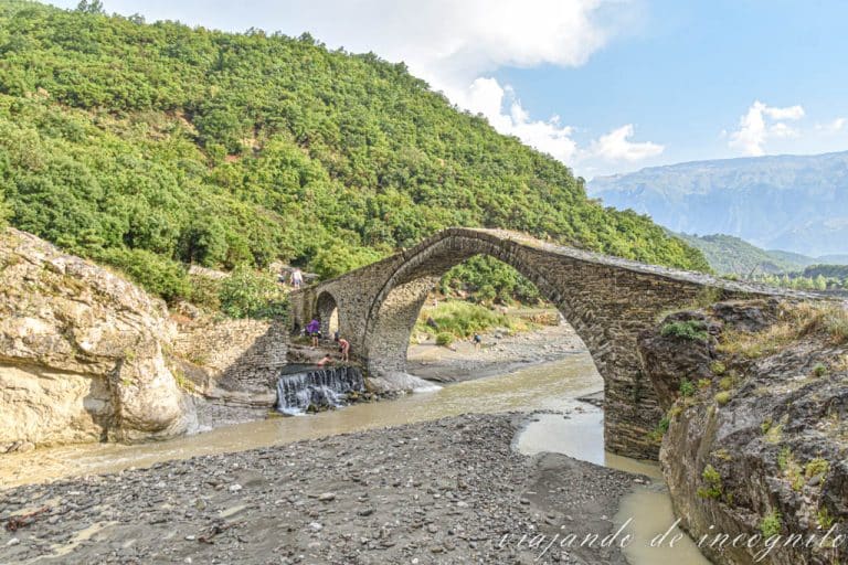 Puente kadiut junto a una piscina natural con gente bañándose en ella