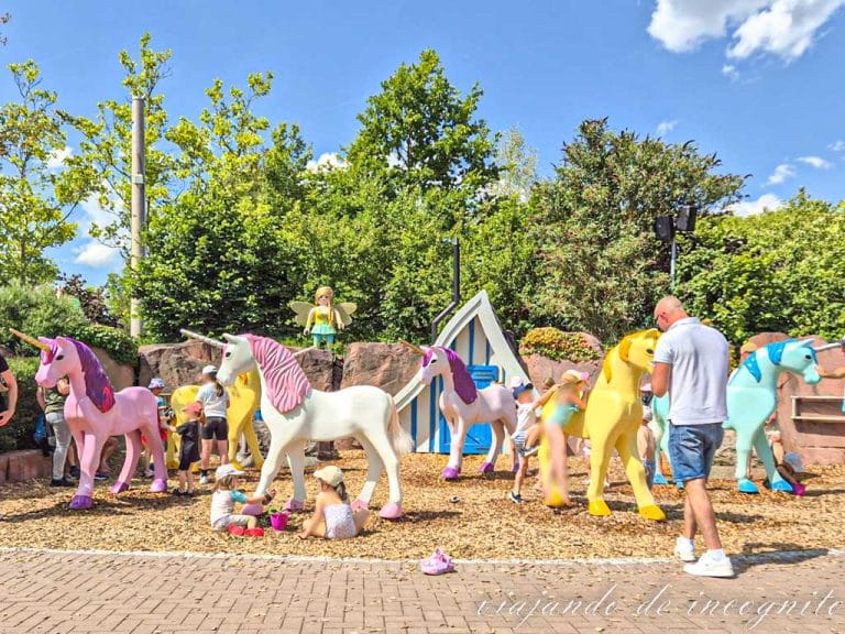 Niños peinan y limpian coloridos unicornios en el parque de Playmobil